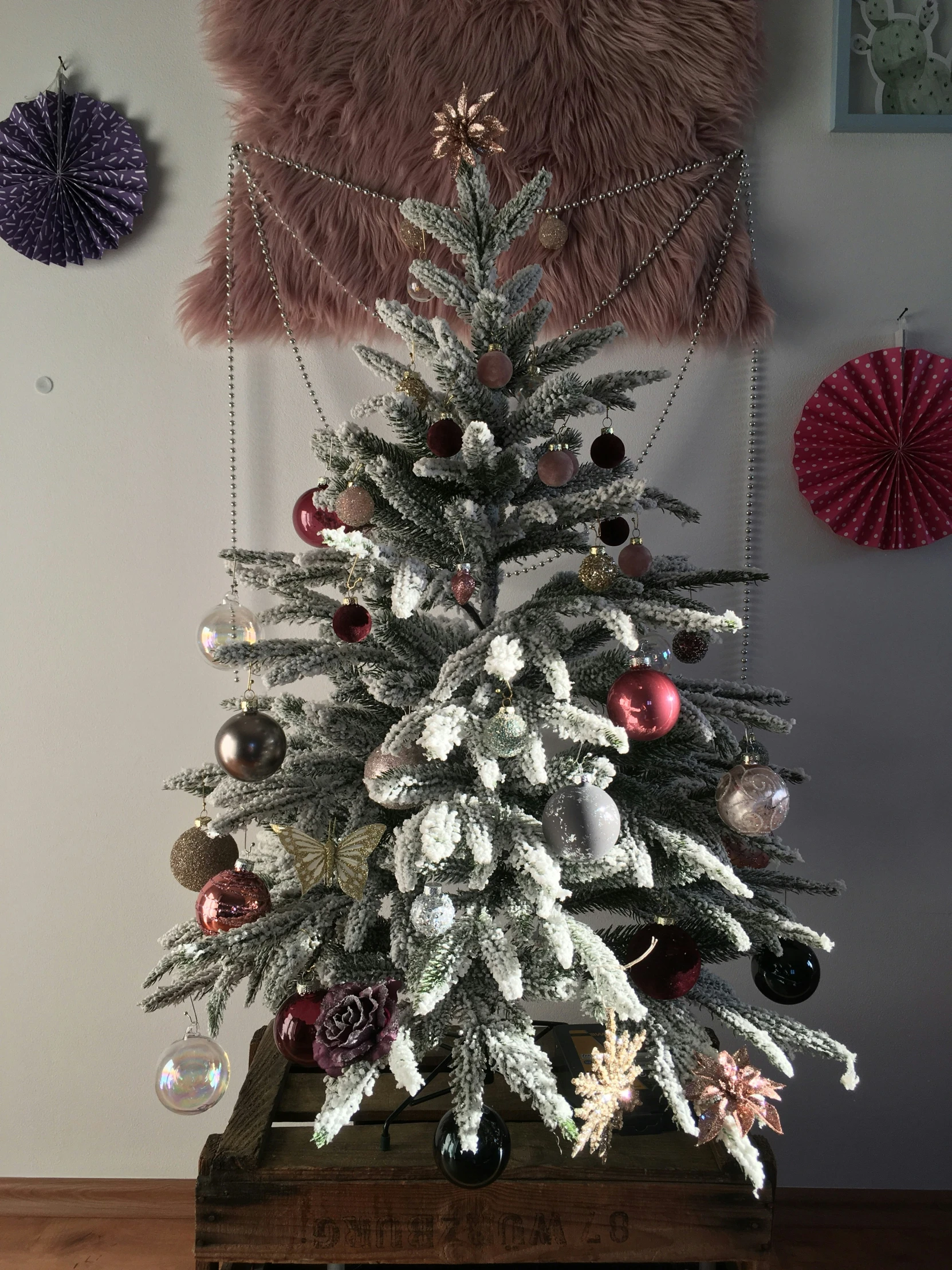 a small white christmas tree with ornaments underneath