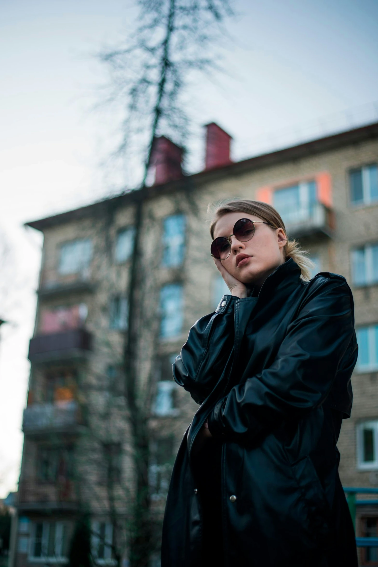 woman in dark sunglasses standing near a building