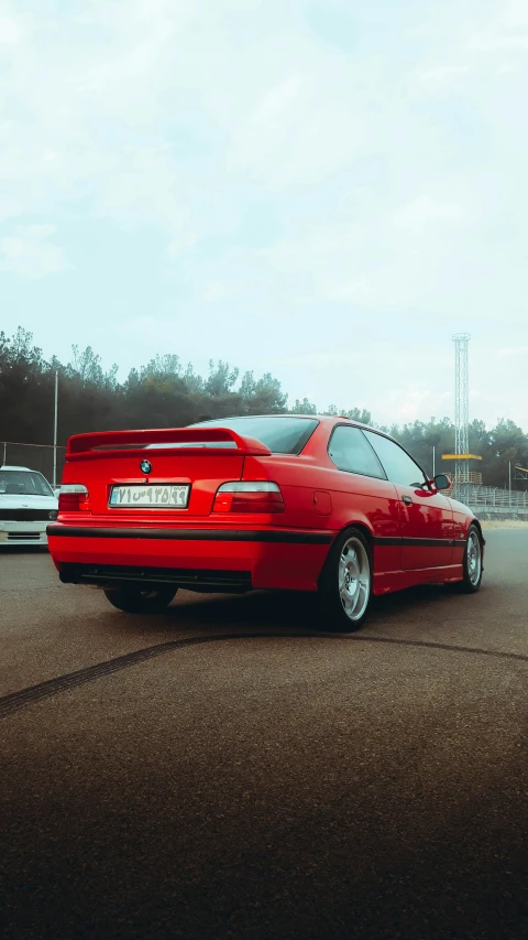 a red car sitting in the middle of a parking lot