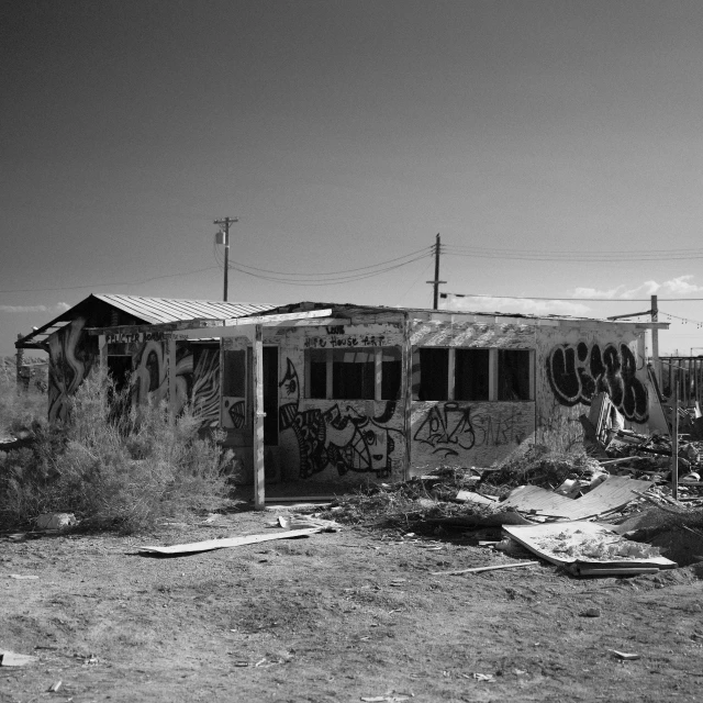 a run down building that is near some telephone poles