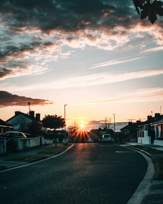 a street scene at sunset with houses in the background