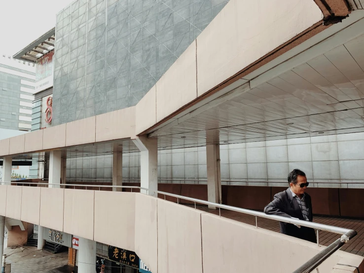 a man standing in the shade on an escalator