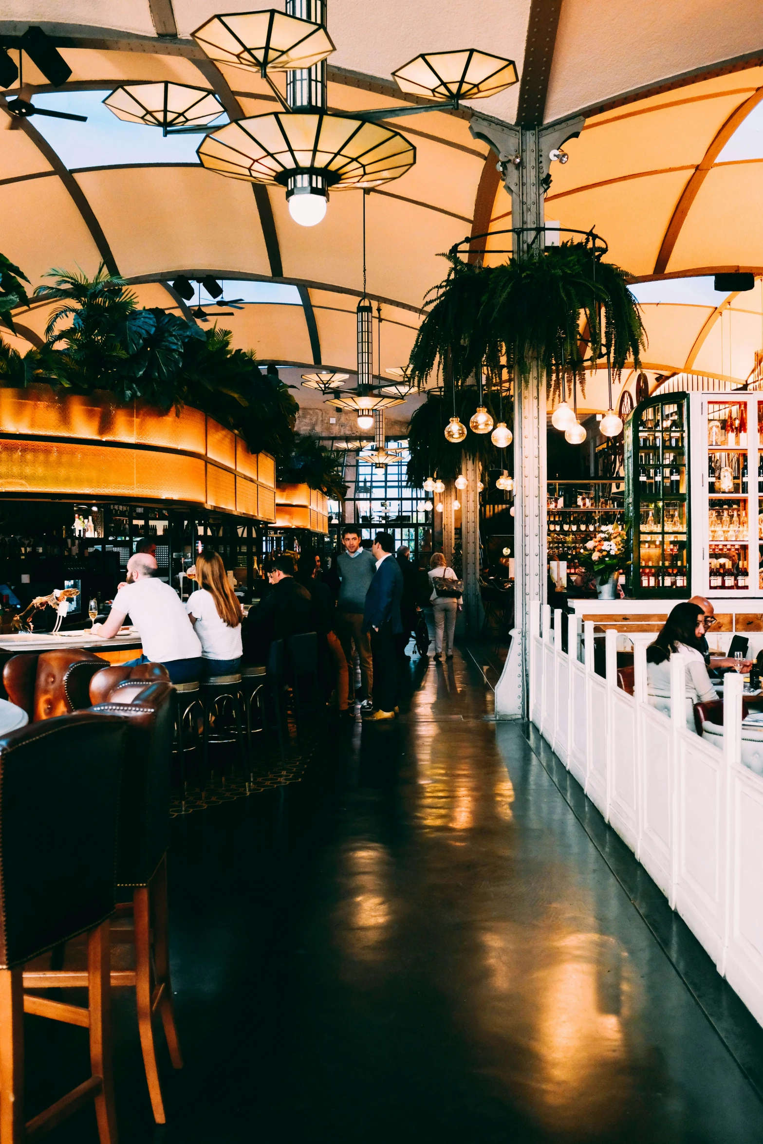 people dining inside of a restaurant under an arched roof