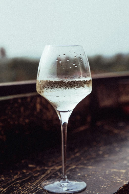 a glass of water on a table near a window