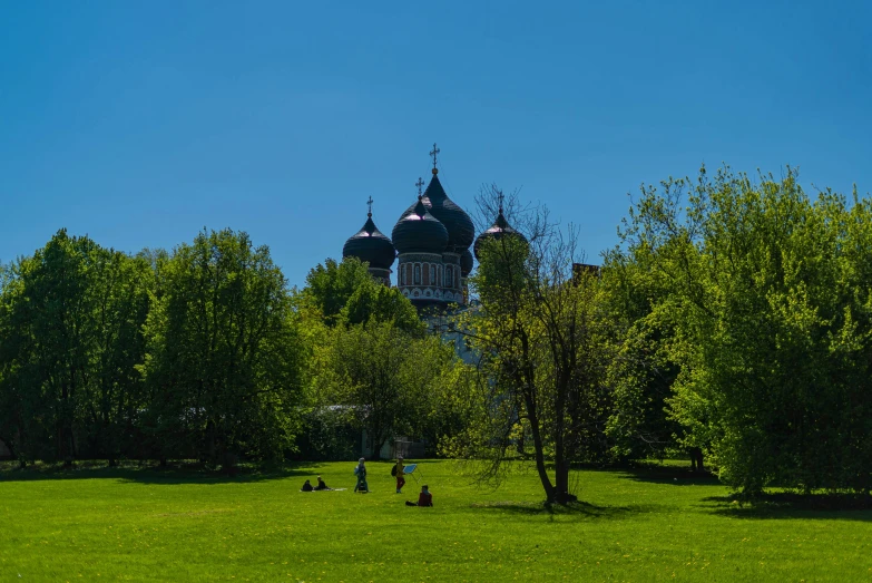 a large park with some people sitting on the grass