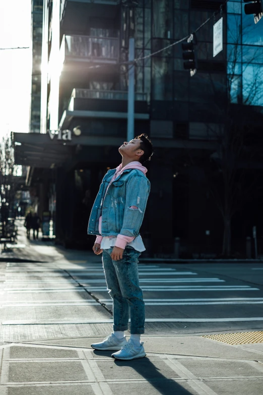 a young man is standing in the street