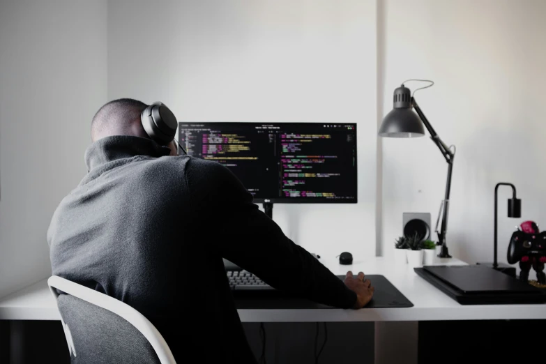 a person wearing headphones is looking at some computer screens