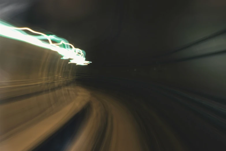 a car moving through a tunnel with lights and blurry motion