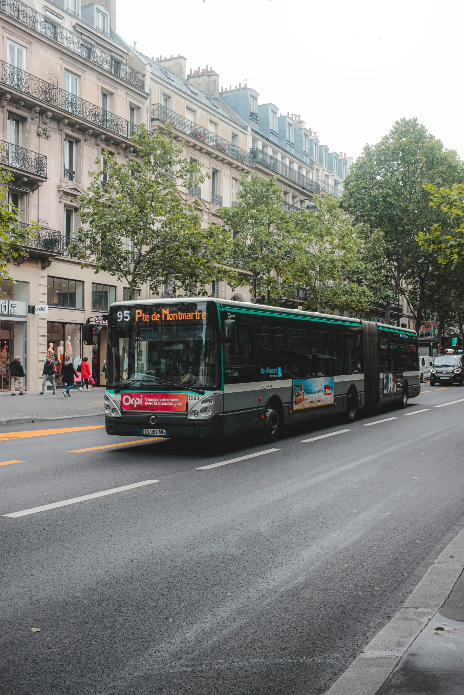 a passenger bus on an empty street in front of some buildings