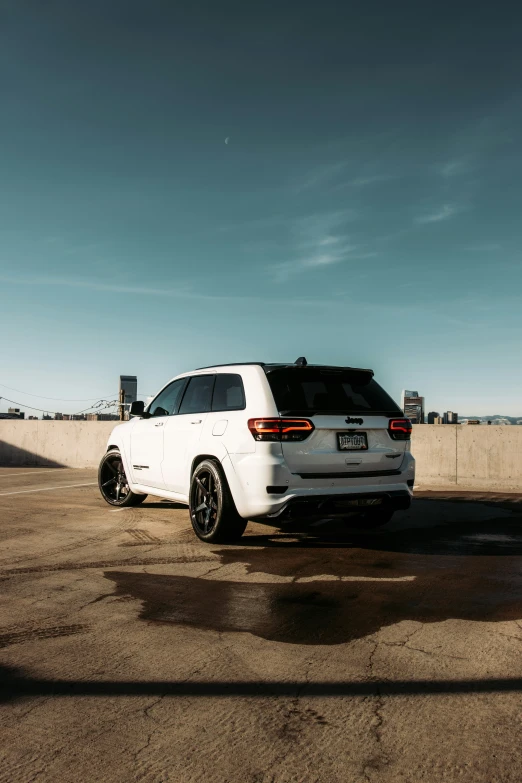 there is a white jeep that is parked near a concrete wall