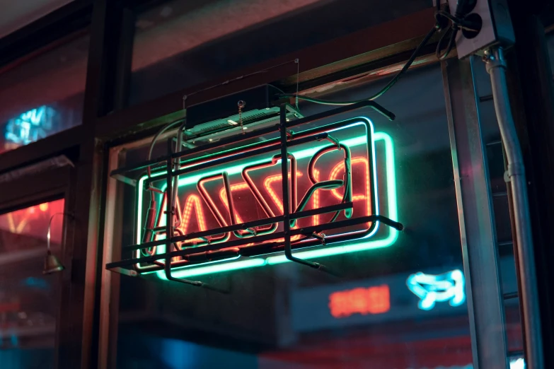 a neon sign hanging from a window on the side of a building