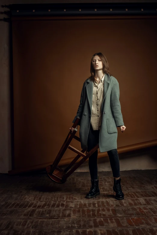 the girl stands in an empty room with a luggage cart