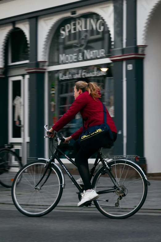 the woman is riding her bike down the street