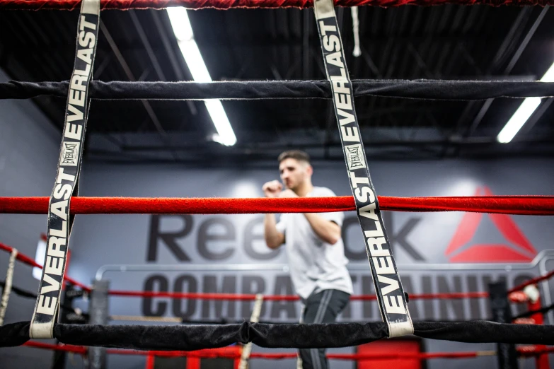 a man talking on the phone inside a boxing ring