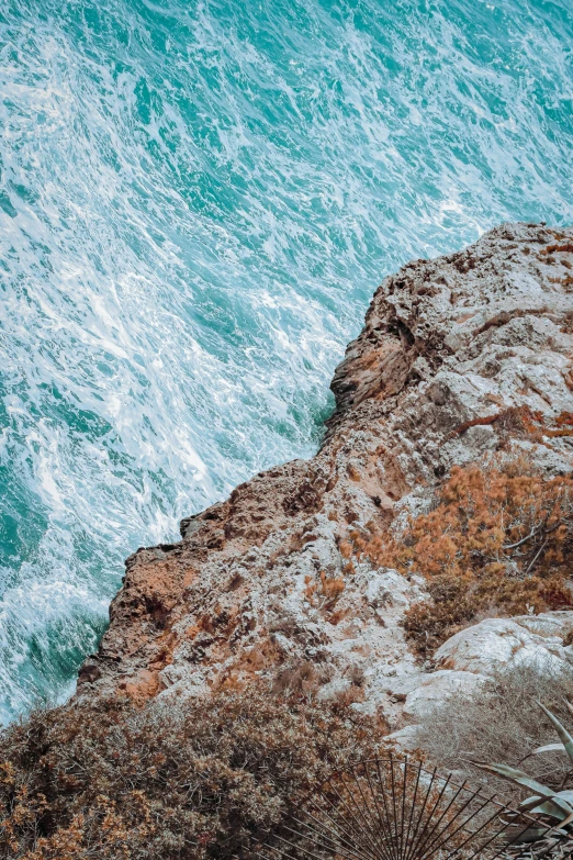 a rock outcropping by the ocean on an overcast day