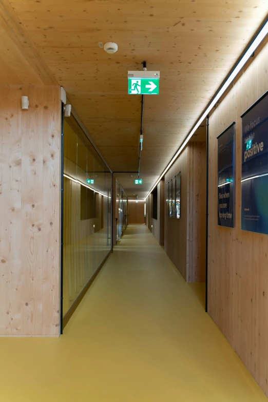 a hallway leading to two restrooms and a light that has a green street sign