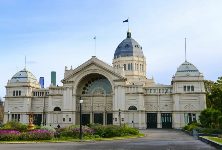 a very tall building with domes that has flowers on each side