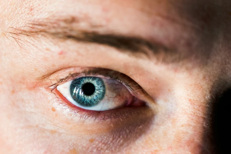 a womans blue eye with green and brown around it