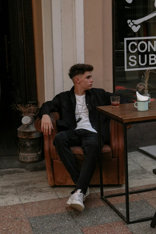 a man sitting at a coffee shop table talking on his cell phone