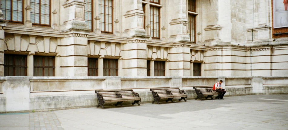 an empty building with three wooden benches next to it