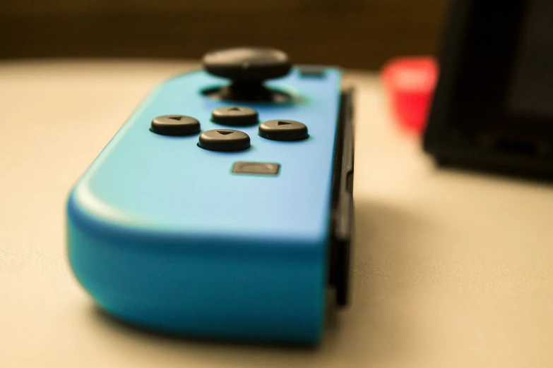 a blue controller with some black ons on it