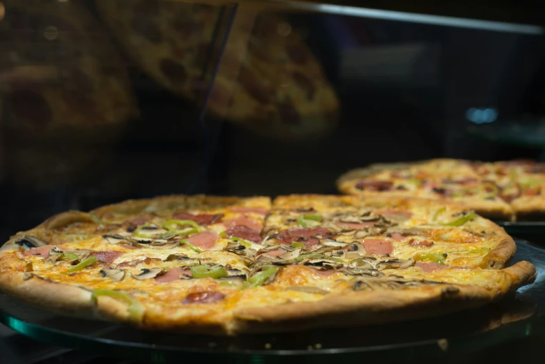 two large cooked pizzas sitting on top of a table