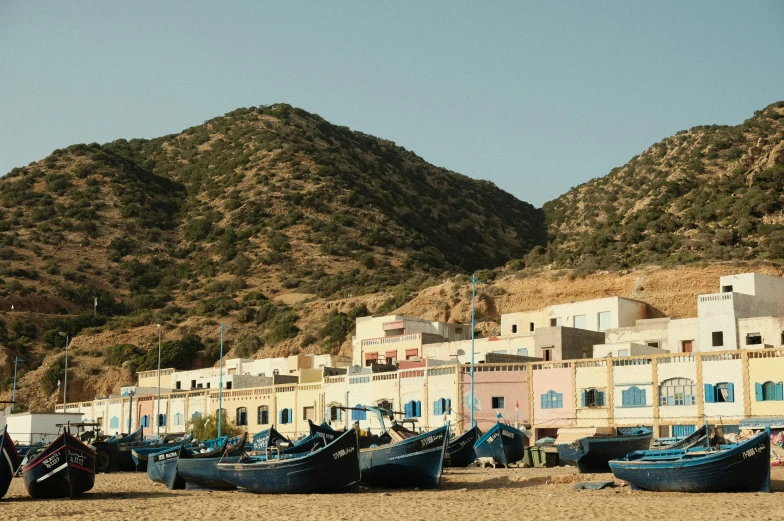 several row boats and some building near mountain