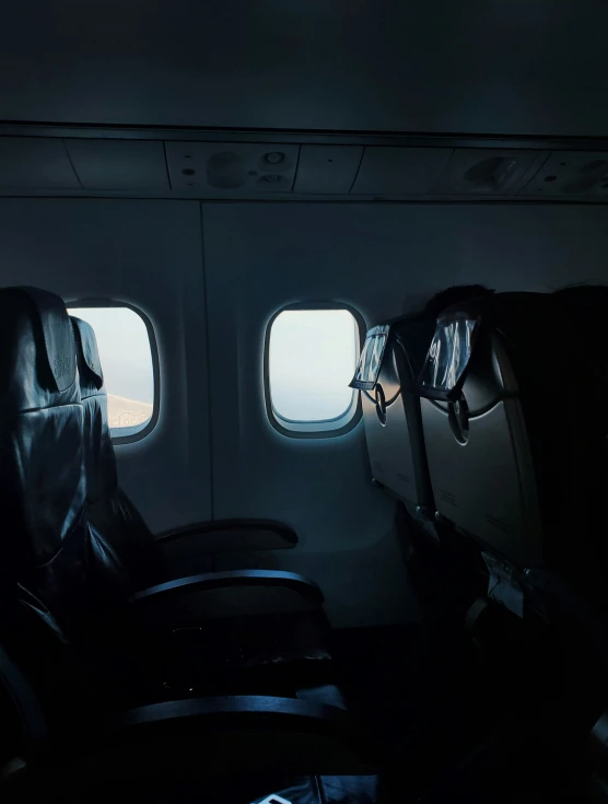 two seats on a airplane with window view of a field