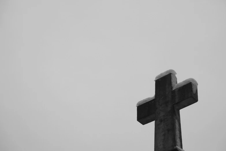 a large wooden cross sitting under a snow covered sky