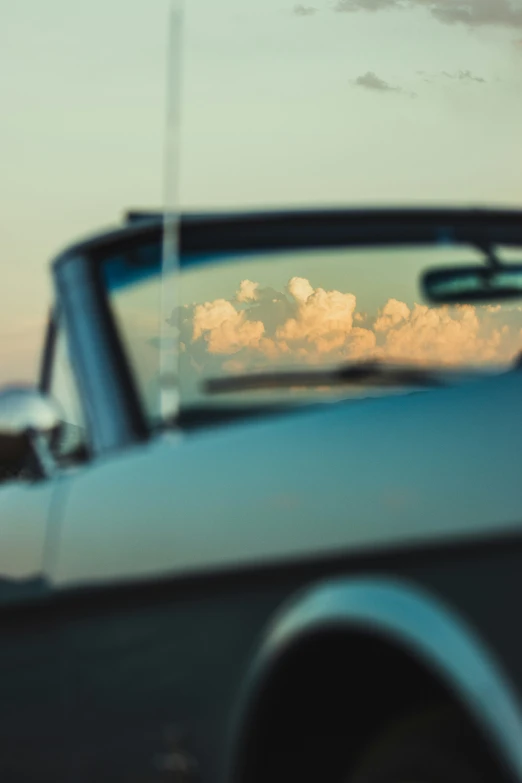 a reflection of the sky from an old vintage car