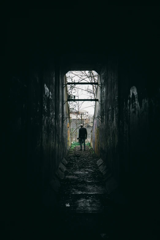 a man standing in a dark hallway holding an umbrella