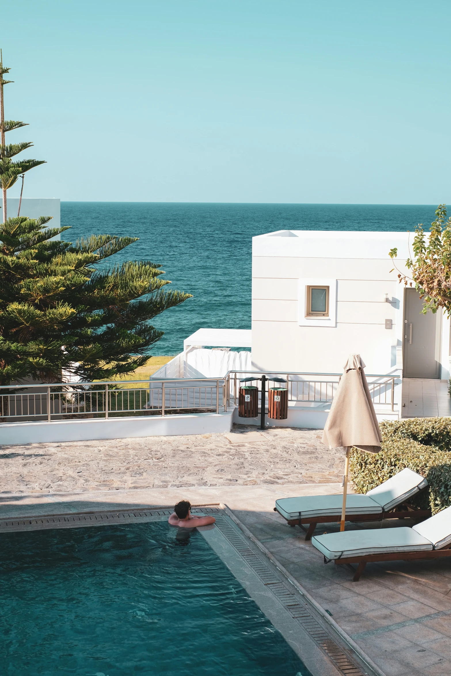 a house with a big pool surrounded by the ocean