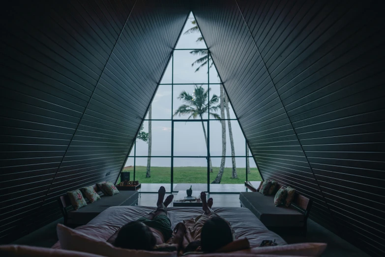 a woman is laying down with her feet on the edge of her bed