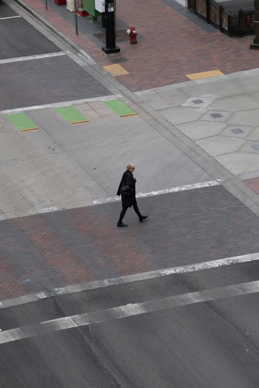 a woman walking down the middle of a city street