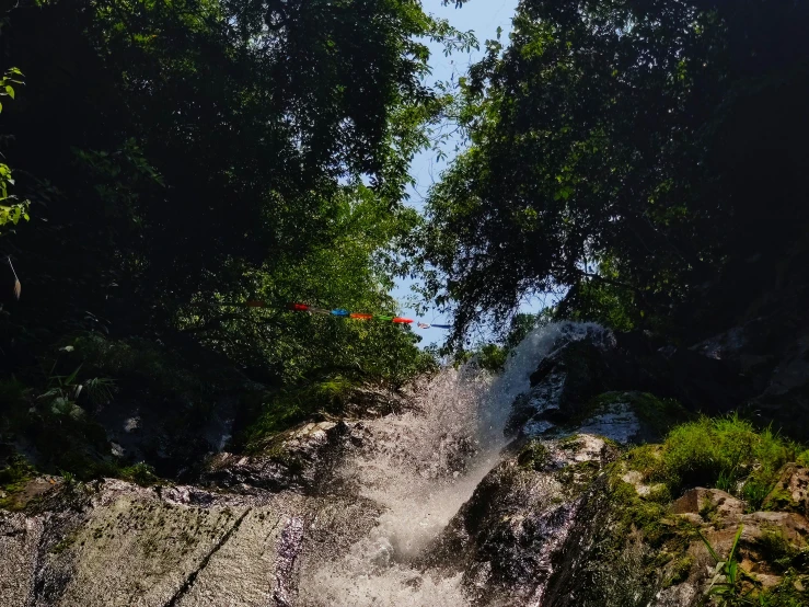 a man with an umbrella standing near a waterfall