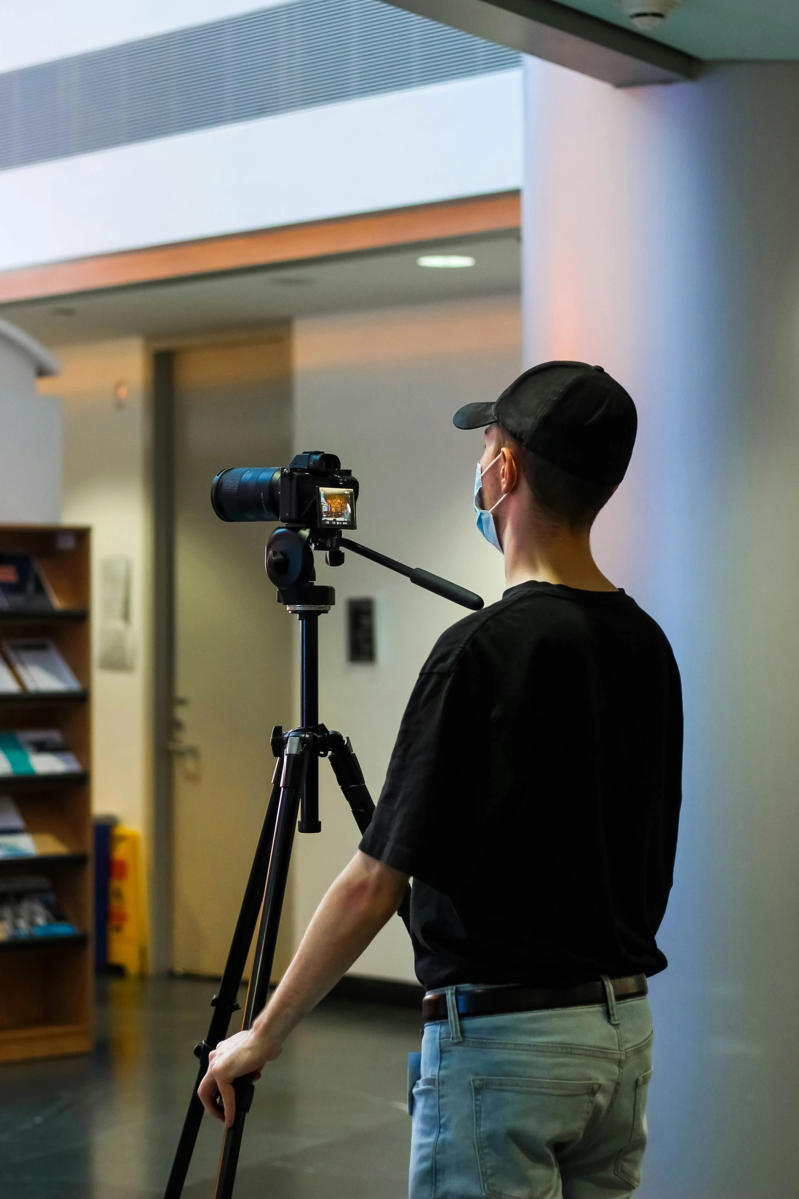 the man in the hat is standing near a tripod