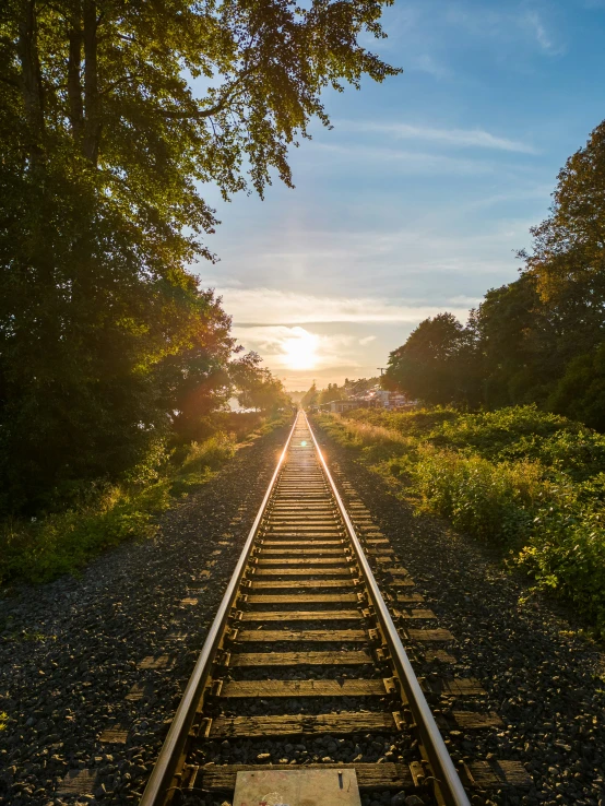 an image of a train track with sun going down