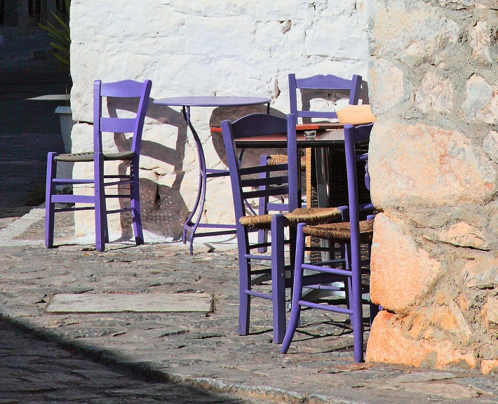 three blue wooden chairs with seats near the edge