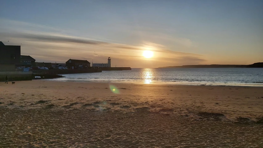 a view of the sunset over a beach with water