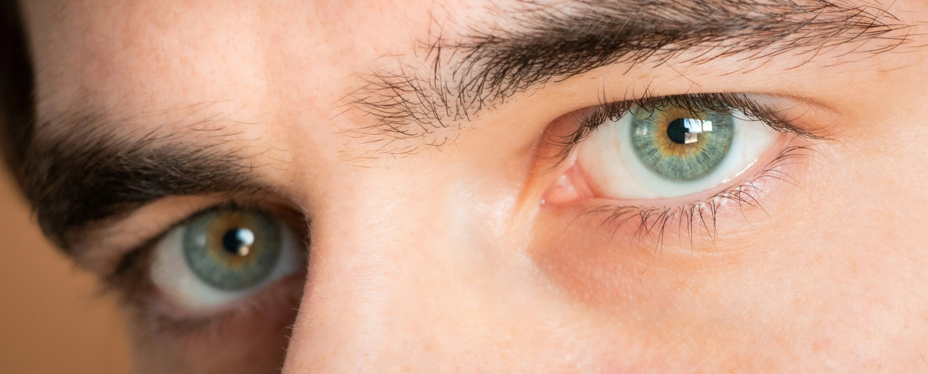 two blue eyes are seen while the man looks at the camera