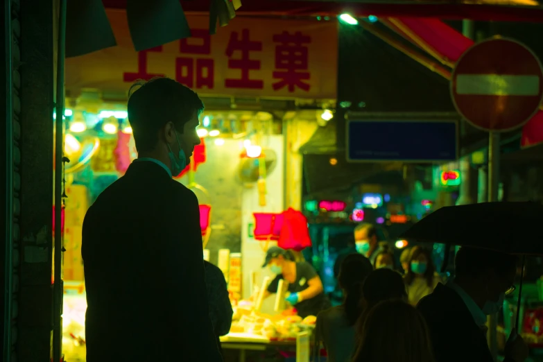 a man stands at an outdoor market in the night