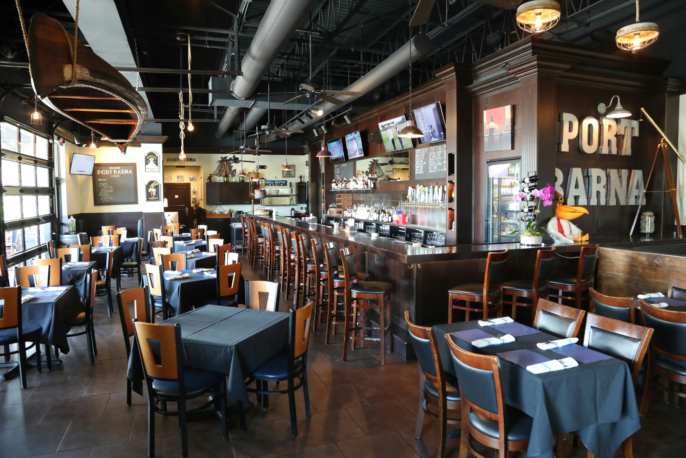 a restaurant with tables covered in cloths and wooden chairs