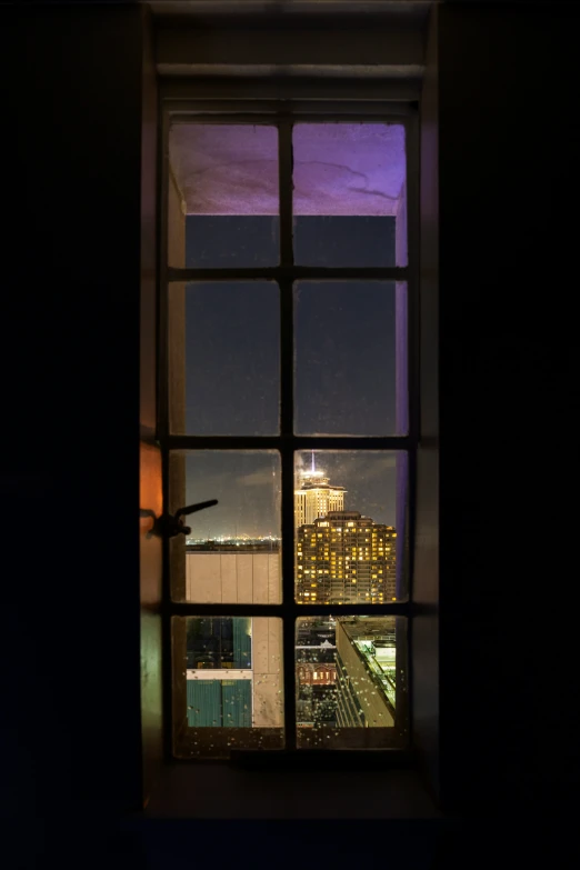 a window with a view of a city at night