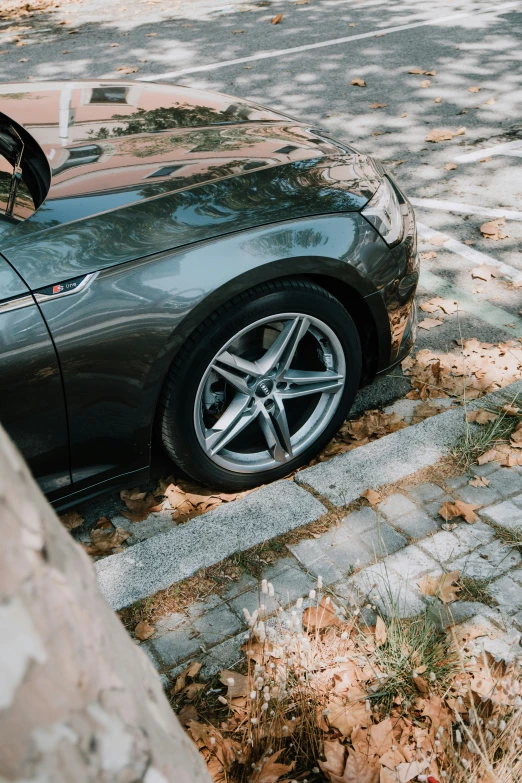 a grey sports car is parked next to the curb