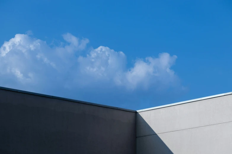 a jet flying in the sky next to a building