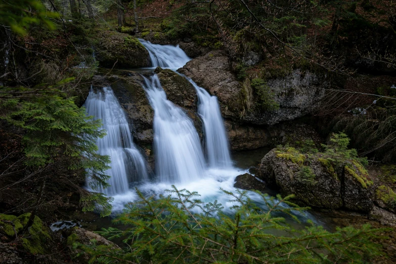 there are waterfalls in the woods near the grass