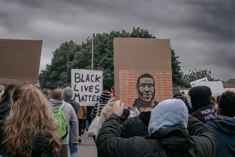 a group of people holding signs on the side of the road