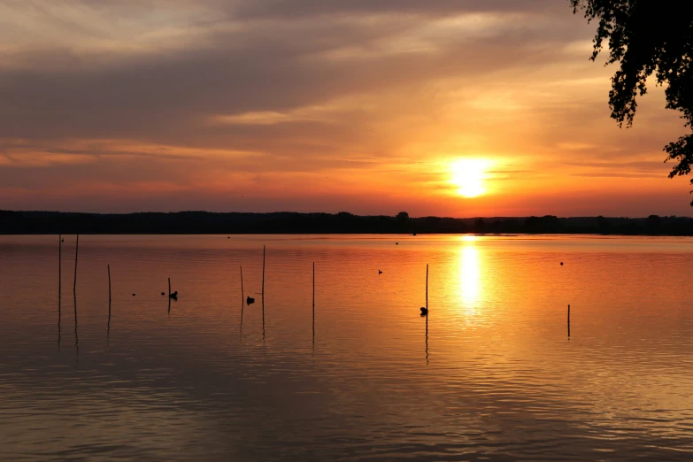 the sun is setting over the large body of water