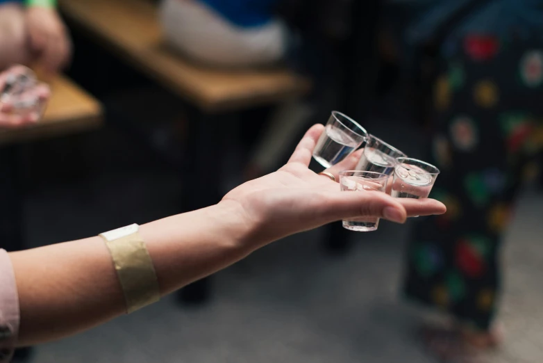 woman in pajamas holding up a glass that holds soing inside