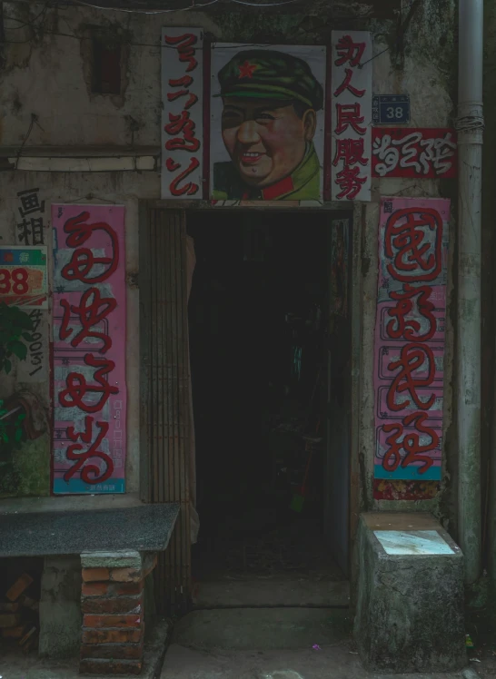 a graffiti wall with a door with a poster and other graffiti on it